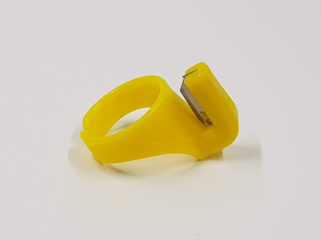 La bague coupe-fils est un anneau en plastique à taille unique qui se porte sur un doigt pour couper facilement les fils.