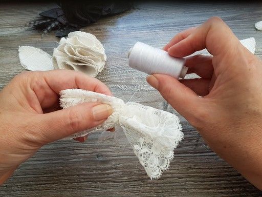 Fixer la dentelle en enroulant un fil autour des plis pour la réalisation d'une fleur en tissu