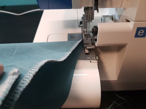 Pour faire un point d'arrêt en fin de surjet, retourner l'ouvrage pour mettre le surjet réalisé à nouveau sous le pied presseur de la surjeteuse et effectuer quelques points en diagonale