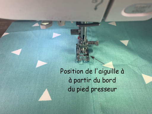 Pour surpiquer le long d'une couture, réglez la position de l'aiguille à une distance égale à la largeur de la surpiqûre à partir du bord du pied presseur