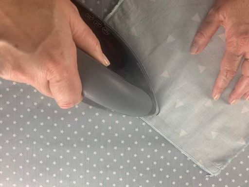 Repassage de la couture à plat pour écraser les points dans les fibres du textile